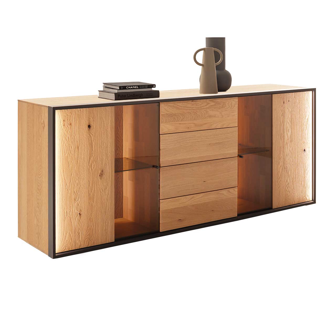 Modernes Sideboard mit klarer Linienführung aus massiver, sandgestrahlter Kerneiche Natur. In der Mitte ein Schubkasten und eine Tür, links und rechts Türen mit beleuchteten Glasausschnitten. Umrahmt von einem dünnen anthrazitfarbenen Metallrahmen.