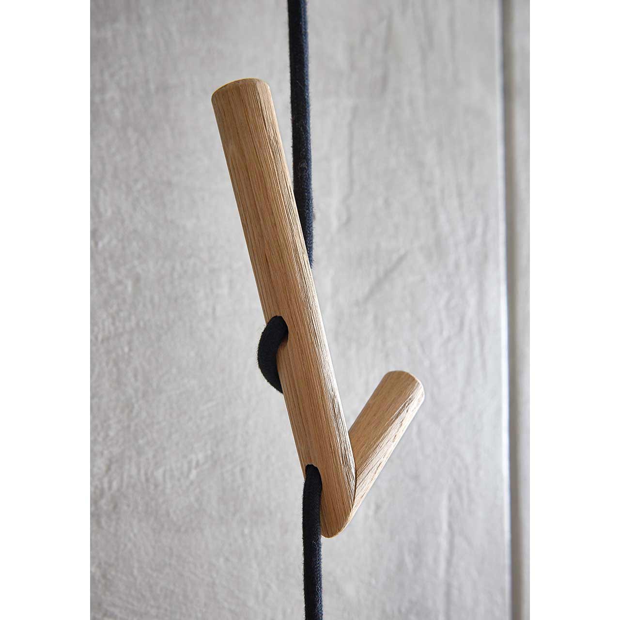 Hartmann SALVO Garderoben - Wandgarderobe 8550G-9011 - Detail Holzhaken Detailaufnahme eines abgerundeten Holzkleiderhakens, der in ein schwarzes Seil der Wandgarderobe SALVO Nr. 9011 eingeflochten ist.