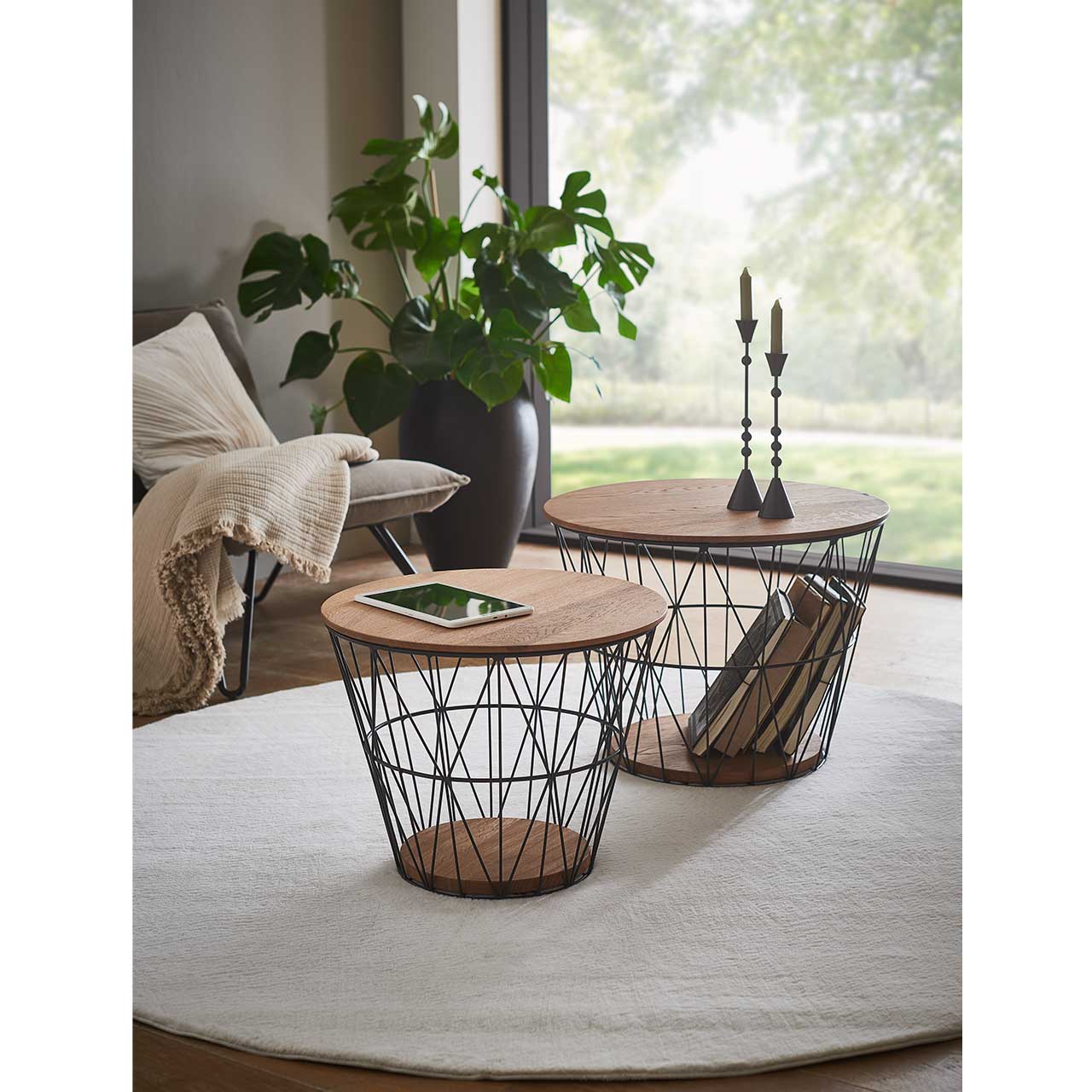 Zwei raffinierte Couchtische mit feinem Metallkorb in Anthrazit und abnehmbarem runden Holzdeckel sowie runder Bodenplatte aus Riffeiche Umato.