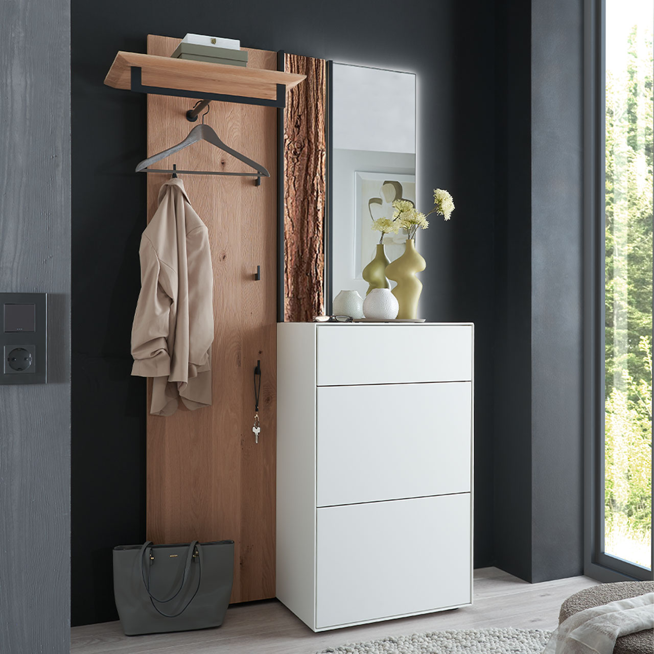 Moderne dreiteilige Garderobe aus Kernbirke und Kerneiche Natur: Wandpaneel aus Holz mit Kleiderstange, Haken und Rinden-Akzent, ein Stauraumschrank mit Schubkasten und Klappen in Lack weiß und ein rechteckiger Spiegel.