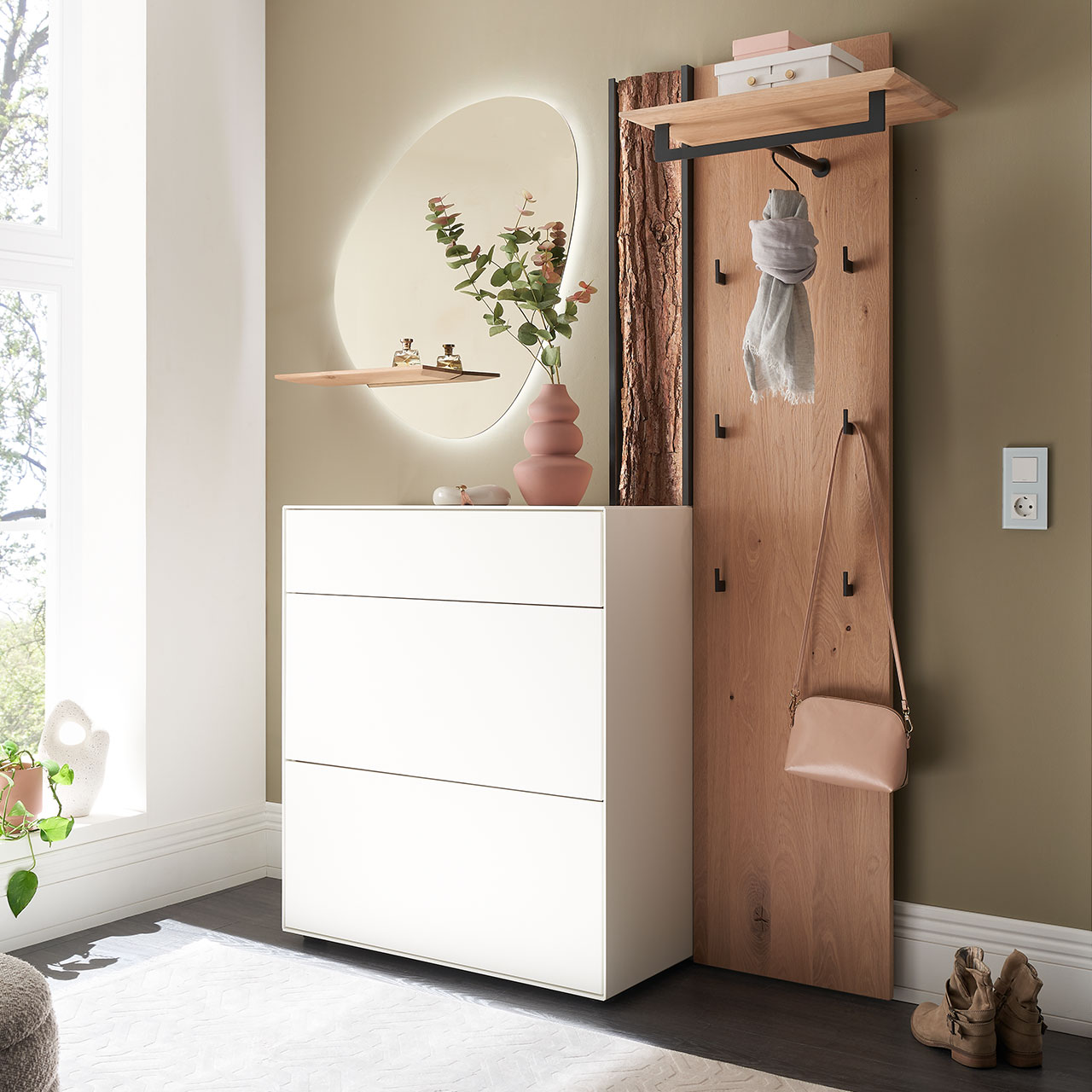 Moderne dreiteilige Garderobe aus Kernbirke und Kerneiche Natur: Wandpaneel aus Holz mit Kleiderstange, Haken und Rinden-Akzent, ein Stauraumschrank mit Schubkasten und Klappen in Lack weiß und ein ovaler Spiegel mit Ablage.
