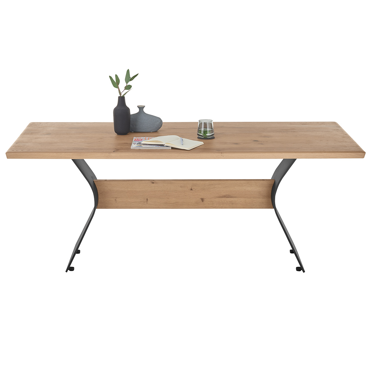 Moderner Esstisch aus heller, massiver Kerneiche mit rechteckiger Tischplatte, geschwungenem 2-Fuß-Gestell in Metall Anthrazit und mittig liegendem Holztravers in hellem Holz - in Frontansicht. Esstisch in drei weiteren Tischkanten verfügbar.