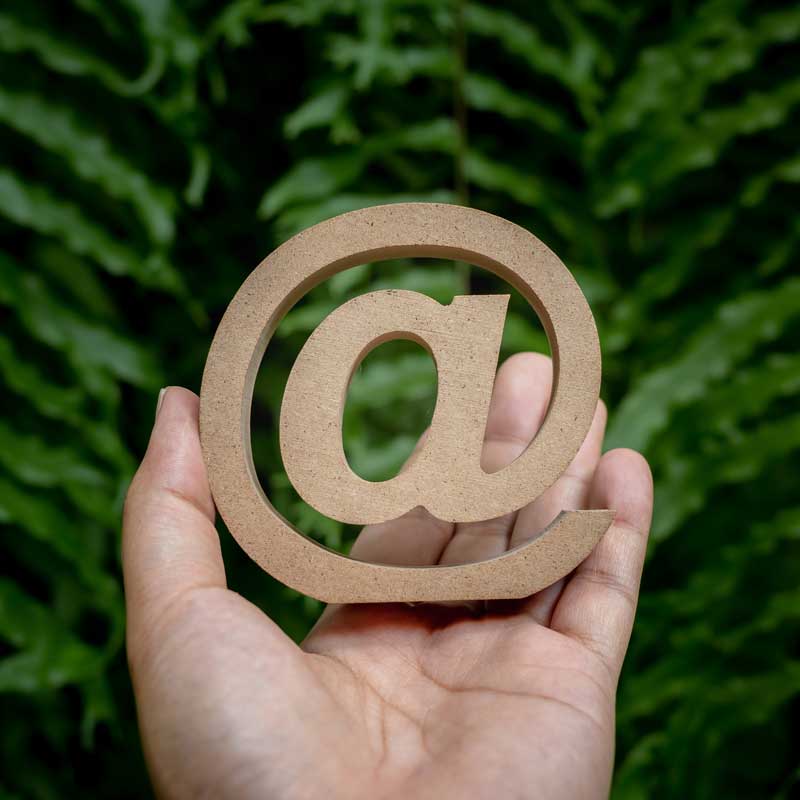 Banner Newsletter - hier können Sie sich für den Newsletter des Möbel Hartmann Online Shops anmelden - direkt abonnieren und keine Rabatte und Neuigkeiten mehr verpassen. Bild zeigt eine Hand mit @- Zeichen aus Holz