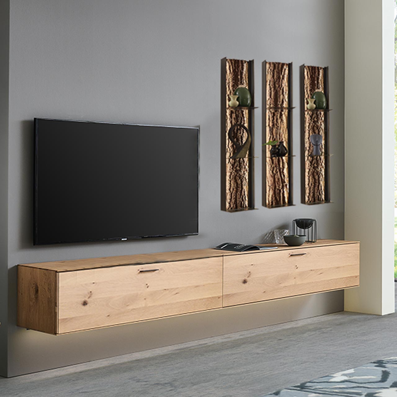 Moderne fünfteilige Wohnwand bestehend aus zwei Hängelowboards aus massiver Kerneiche Natur, und drei beleuchteten Metallregalen mit je drei Ablageböden und sichtbarer Rinden-Rückwand.