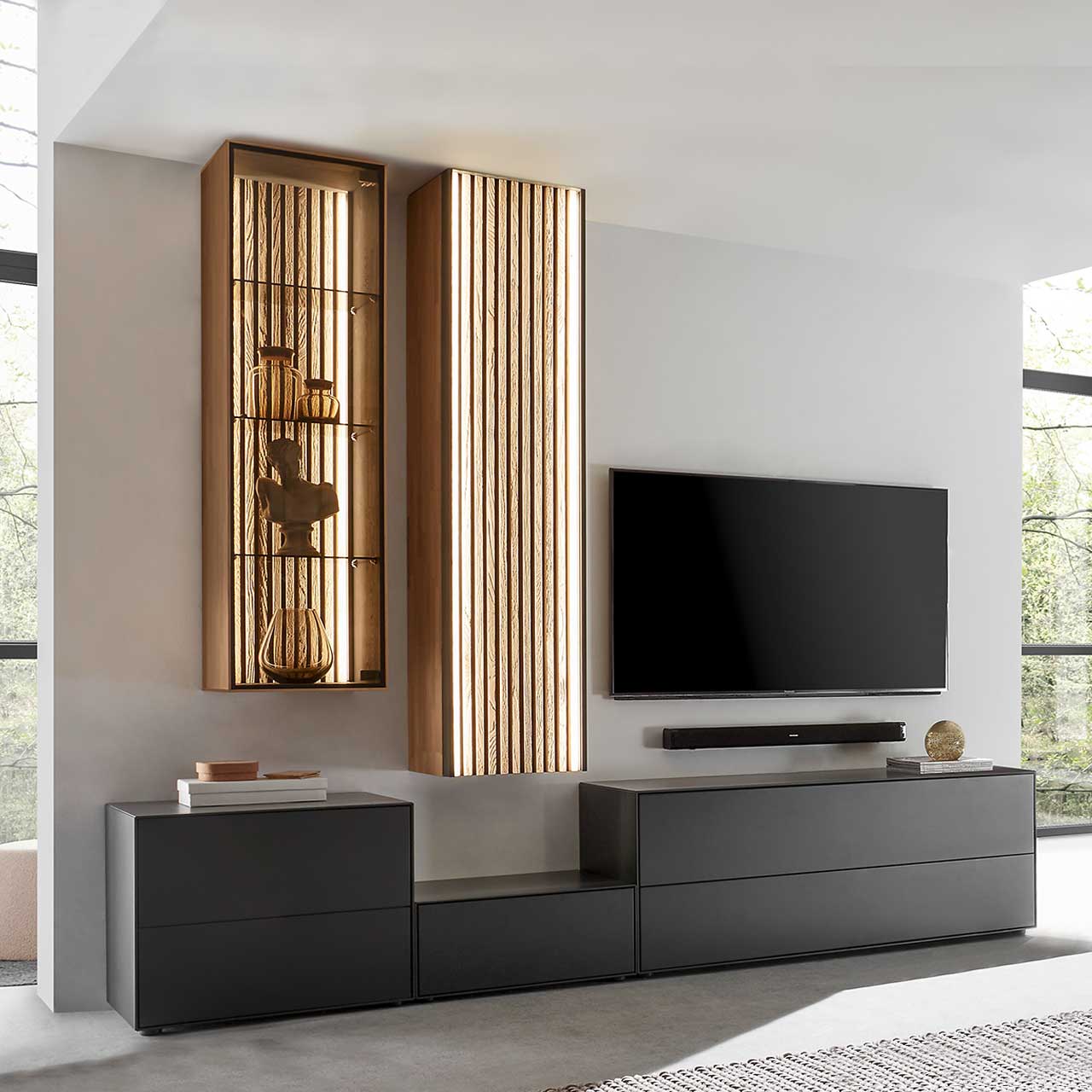 Hartmann SELINO - Wohnwand 8560 Nr. V30 Modernes Wohnzimmer mit Möbeln aus Birke anthrazit und hellem Massivholz mit Lamellen: Drei unterschiedlich hohe Lowboards, darüber hängend eine Vitrine in hellem Holz und ein Hochschrank mit Lamellen.