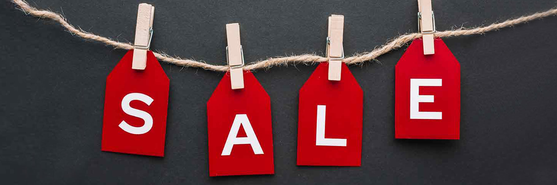 Reduzierte Möbel der Marke Hartmann: SALE Banner für reduzierte Wohnwände und Möbel. Das Wort SALE in Großbuchstaben mit Rabattzeichen in dunkelrot auf milchfarbigem Hintergrund mit abgebildeter Massivholz Wohnwand.