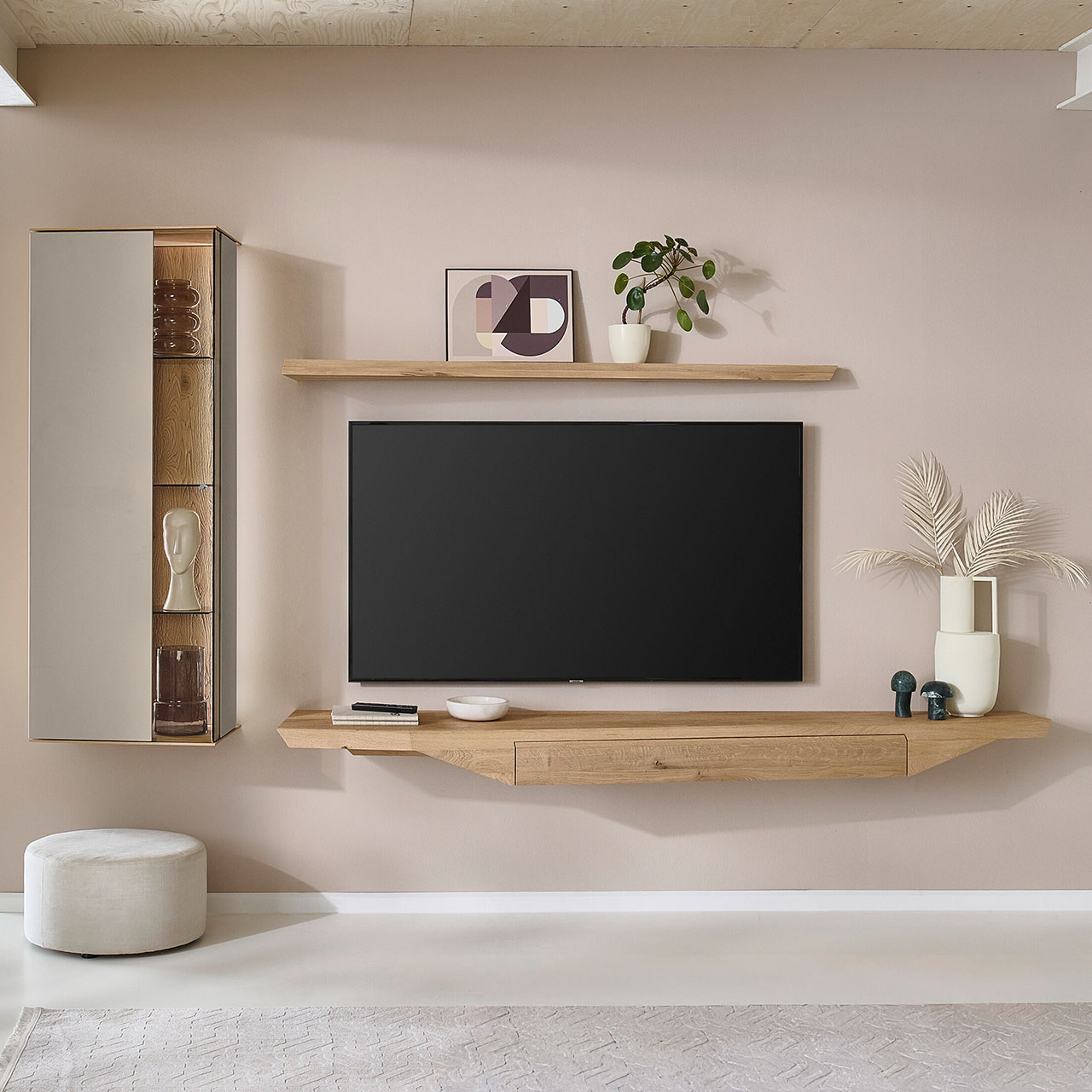 Moderne vierteilige Wohnwand aus massiver Kerneiche Natur mit Lack Sand und Riffholz, bestehend aus einem Hängelowboard mit Schubkasten aus massivem Riffholz einer hohen Hängevitrine in Holz/Lack sowie einem Holz-Wandboard - im asymmetrischen Design.