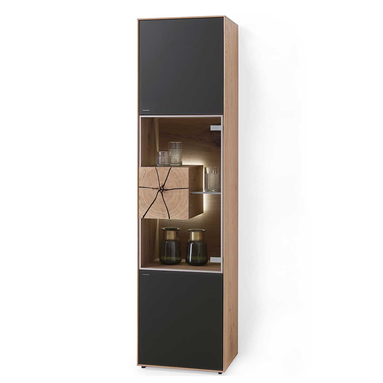 Hartmann CAYA - Standvitrine 7170-0052A - Türanschlag rechts Moderne Standvitrine aus massiver Kerneiche Umato mit Mattglas anthrazit Front, mittig mit beleuchtetem Glasausschnitt, Glasboden und Hirnholzblock aus hellem Holz.