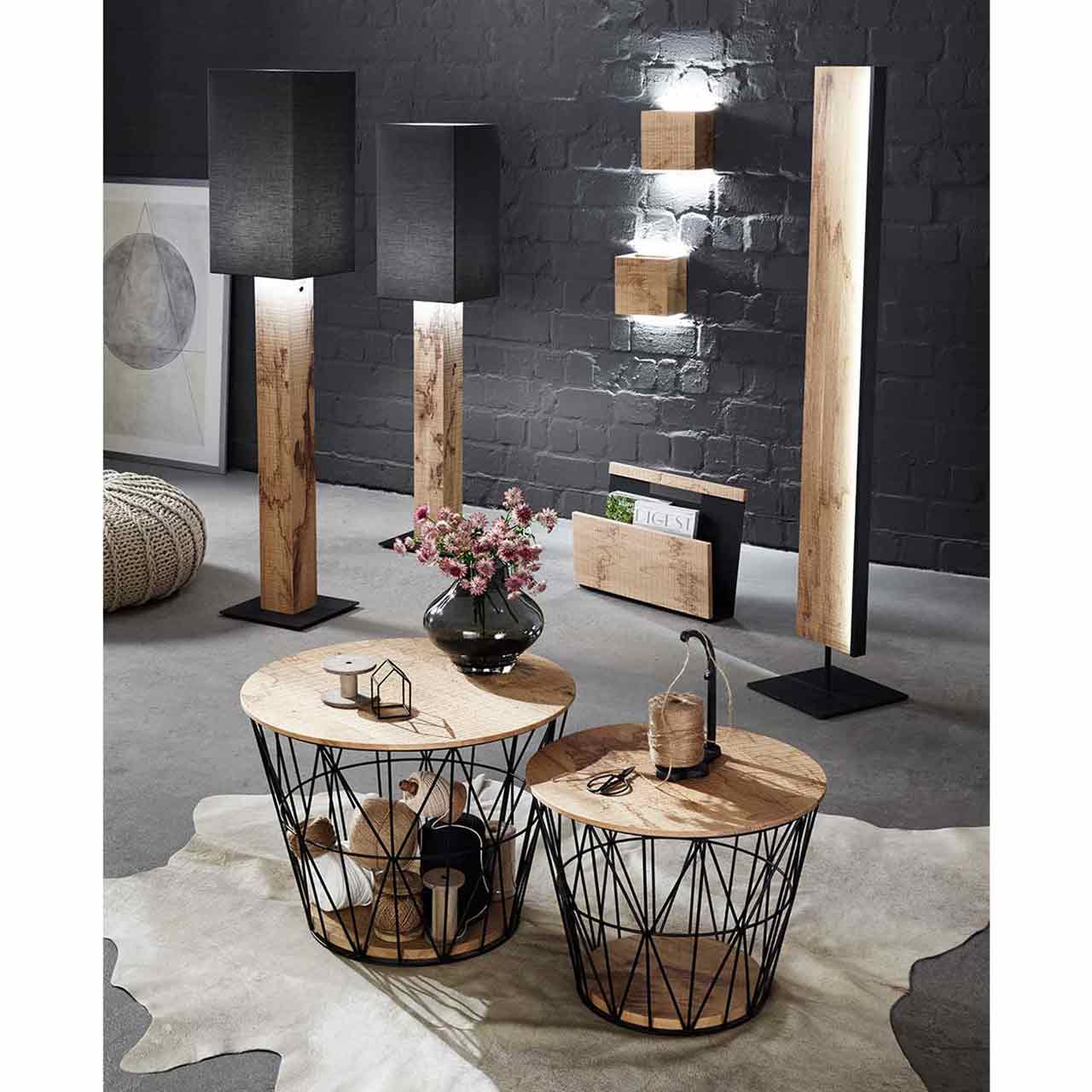 Zwei Stehlampen mit Stofflampenschirm und Holzfuß, zwei Wandlampen mit Holzkorpus, ein Holz-Zeitungsständer, eine Holzstehlampe. Davor zwei runde Couchtische mit feinem Metallkorb in Anthrazit und abnehmbarem Holzdeckel - im Wohnzimmer stehend.
