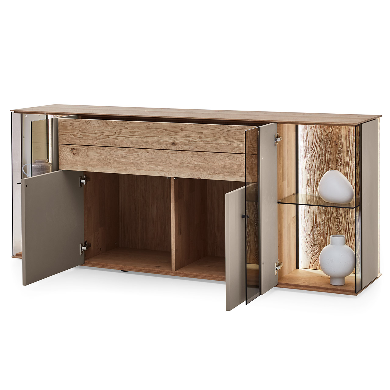 Moderne Kommode aus Massivholz mit Lackfronten in Sand und edlem Riffholz. Mit zwei geöffneten Lacktür unten, einem geöffneten, langen Schubkasten mit Riffholzfront oben und je einer Glas-Lacktür rechts und links mit beleuchteter Riffholzrückwand.