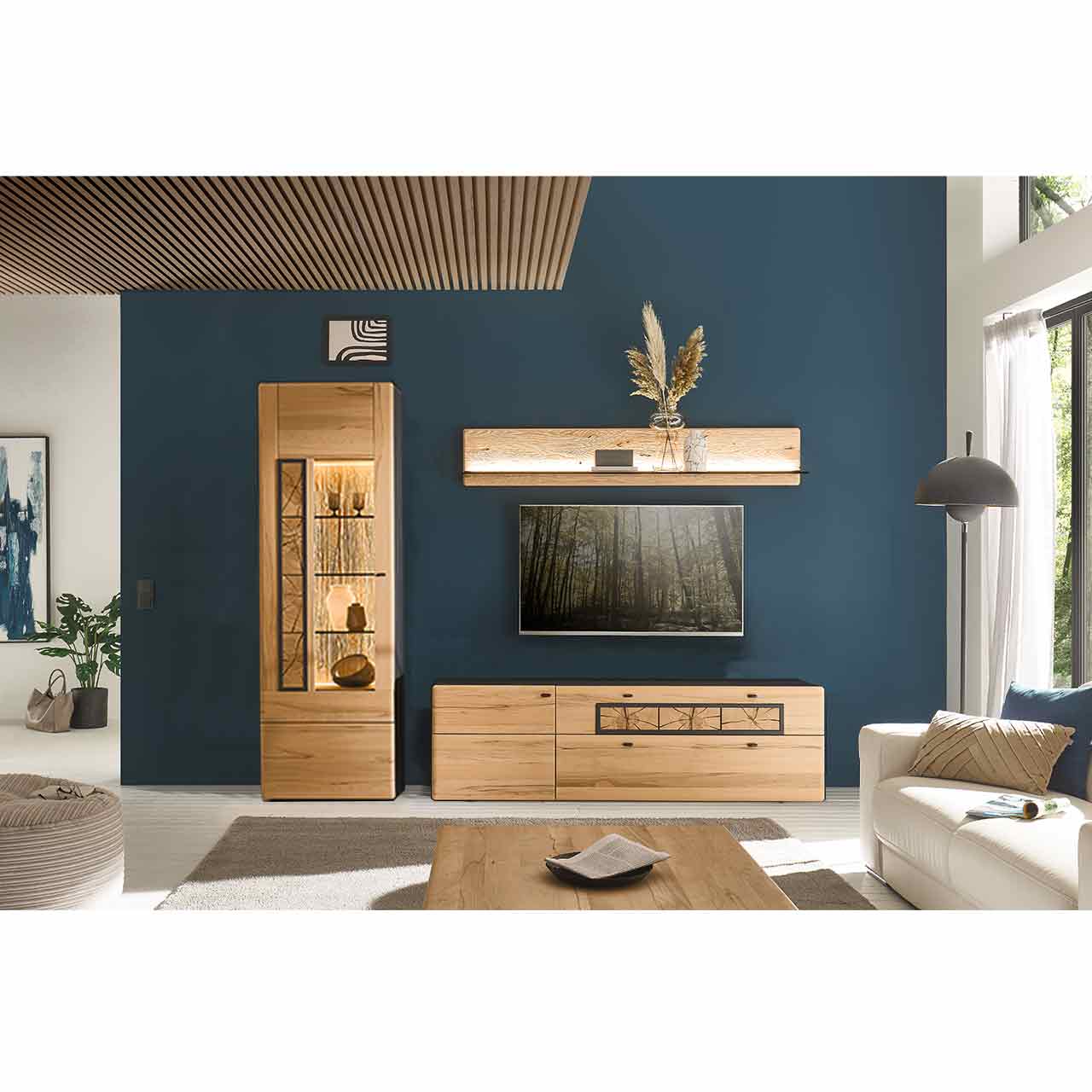 Modernes Wohnzimmer mit Fernseher und 3teiliger Massivholzwohnwand in edler Kernbuche mit dekorativen Hirnholzscheiben. Die passende Hochvitrine, Lowboard und Wandpaneel harmonieren perfekt vor der dunkelblauen Wand und dem passenden Couchtisch.