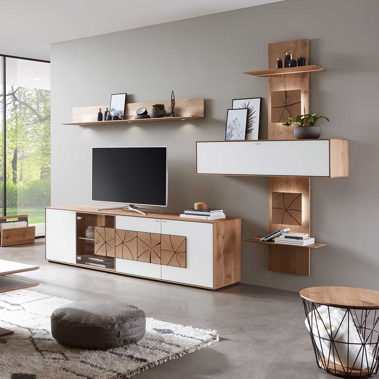 Moderne Massivholz Wohnwand aus Kerneiche Umato mit Mattglas weiß Fronten: Lowboard mit Glasausschnitt und Hirnholz, Wandregal aus Holz, schlichter Hängeschrank eingefasst in ein Holzwandpaneel mit Ablageböden und beleuchteten HIrnholzscheiben.