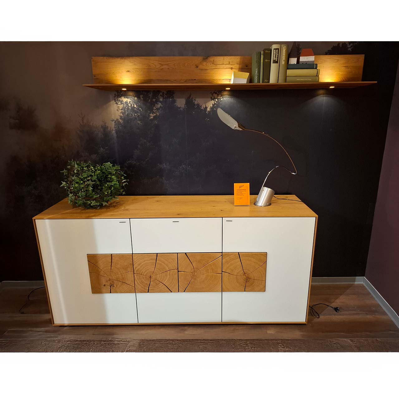 Hartmann SALE Möbel - CAYA Sideboard & Wandpaneel im Set 7170-4177W und 1181 - inkl. Beleuchtung / Originalbild Ausstellung Möbel ZweierSet: Ein modernes Sideboard aus massiver Kerneiche Umato mit weißfarbenen Mattglasfronten und vier dekorativen, rechteckigen Hirnholzscheiben und ein Wandpaneel aus massivem Holz mit Ablageboden und Spotbeleuchtung.