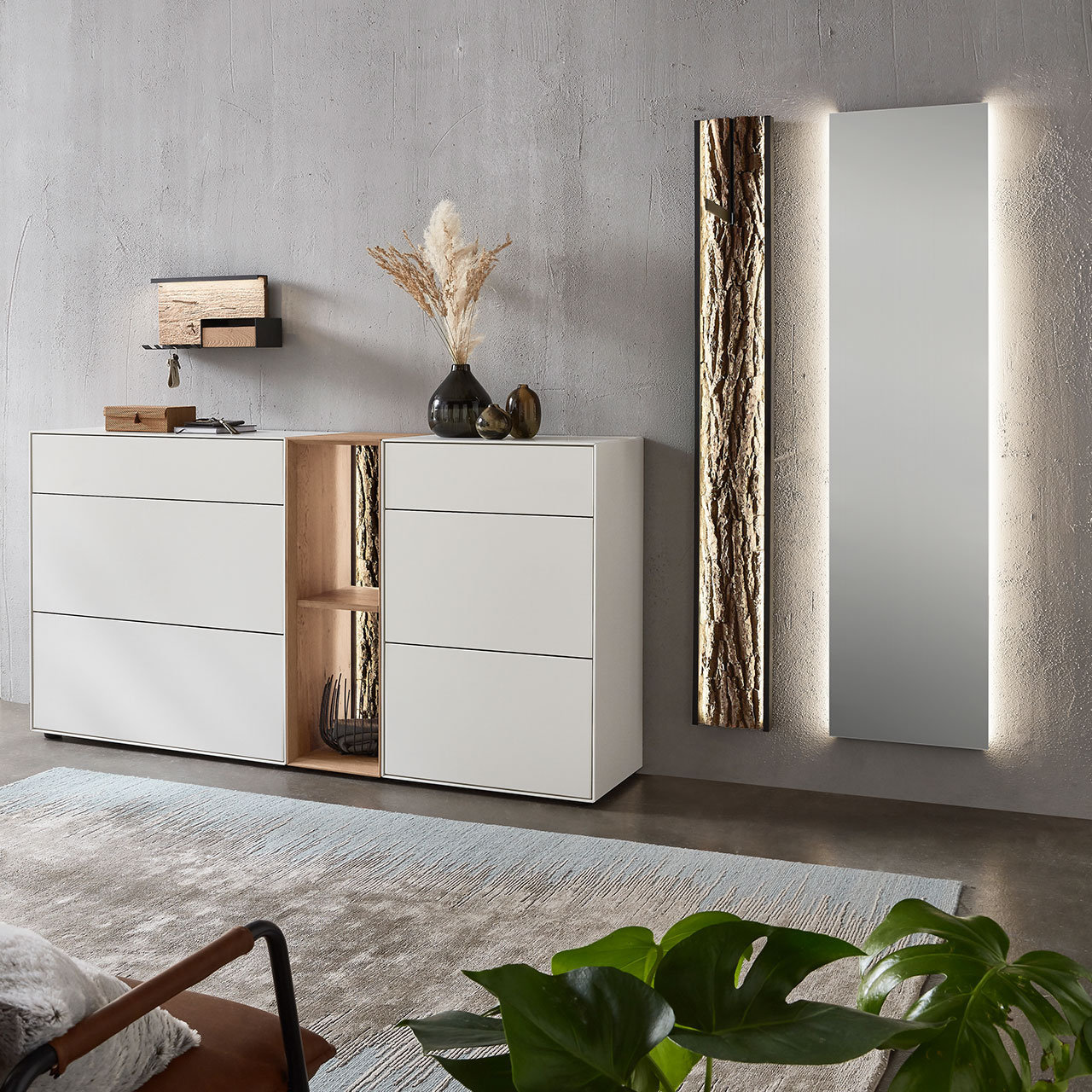 Moderne fünfteilige Garderobe aus massiver Kernbirke und Kerneiche Natur: Regalelement mit Rinden-Rückwand zwischen zwei weiß lackierten Stauraumschränken, dazu ein Garderobenpaneel mit Rinden-Akzent und ein rechteckiger Spiegel.