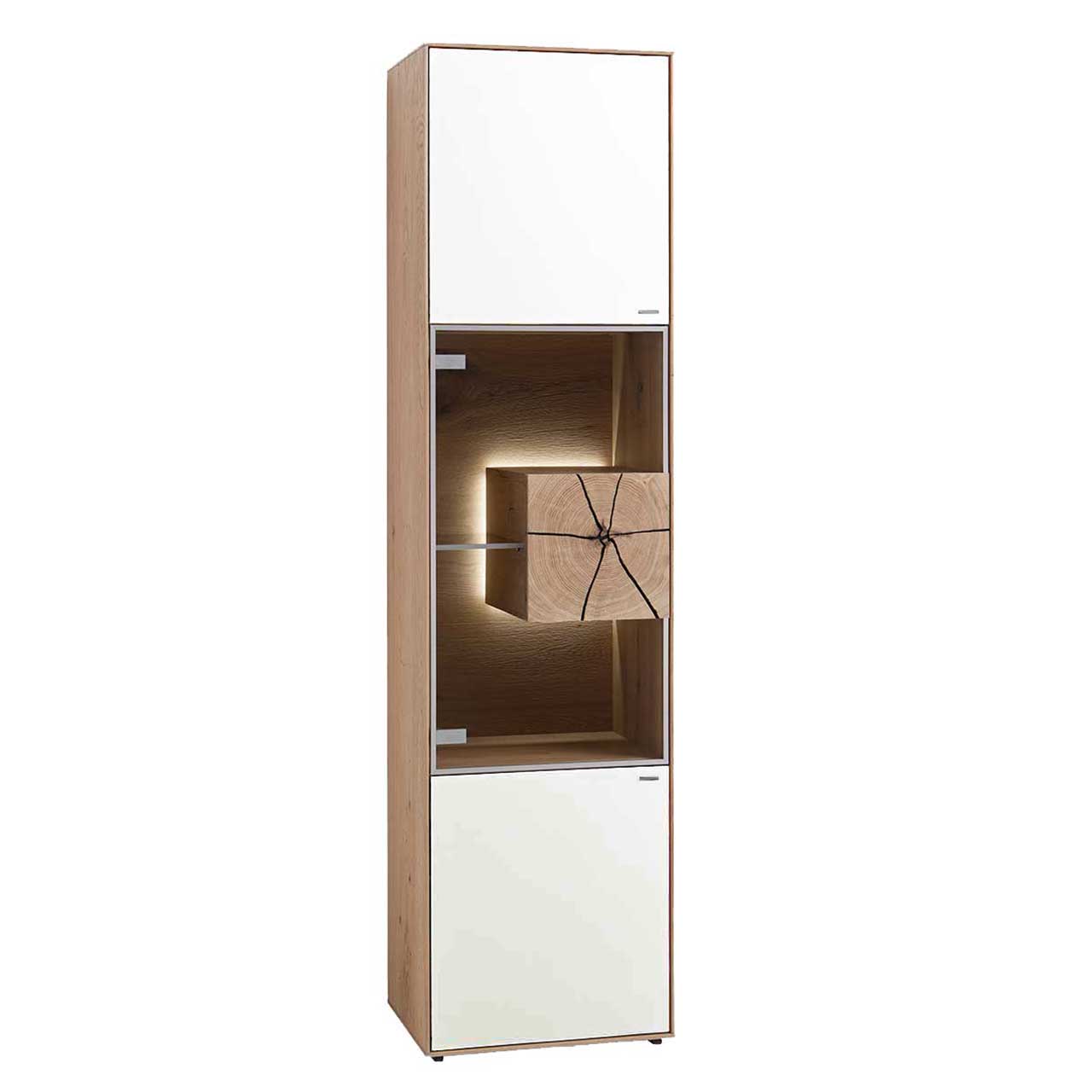 Hartmann CAYA - Standvitrine 7170-0055W - Türanschlag links Moderne Standvitrine aus massiver Kerneiche Umato mit Mattglas weiß Front, mittig mit beleuchtetem Glasausschnitt, Glasboden und Hirnholzblock aus hellem Holz.