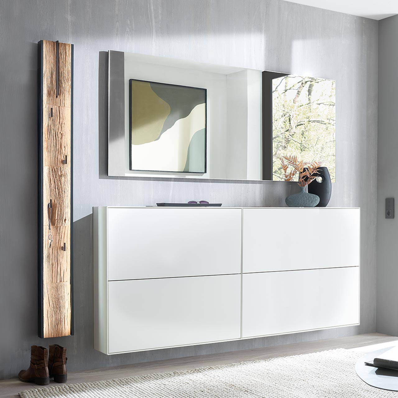 Moderne vierteilige Garderobe aus massiver Kernbirke weiß lackiert: Zwei Schuhkipper in Lack weiß, darüber rechteckiger Wandspiegel, links ein Garderobenpaneel mit ausklappbarer Kleiderstange, vier Kleiderhaken und Spaltholz-Akzent.
