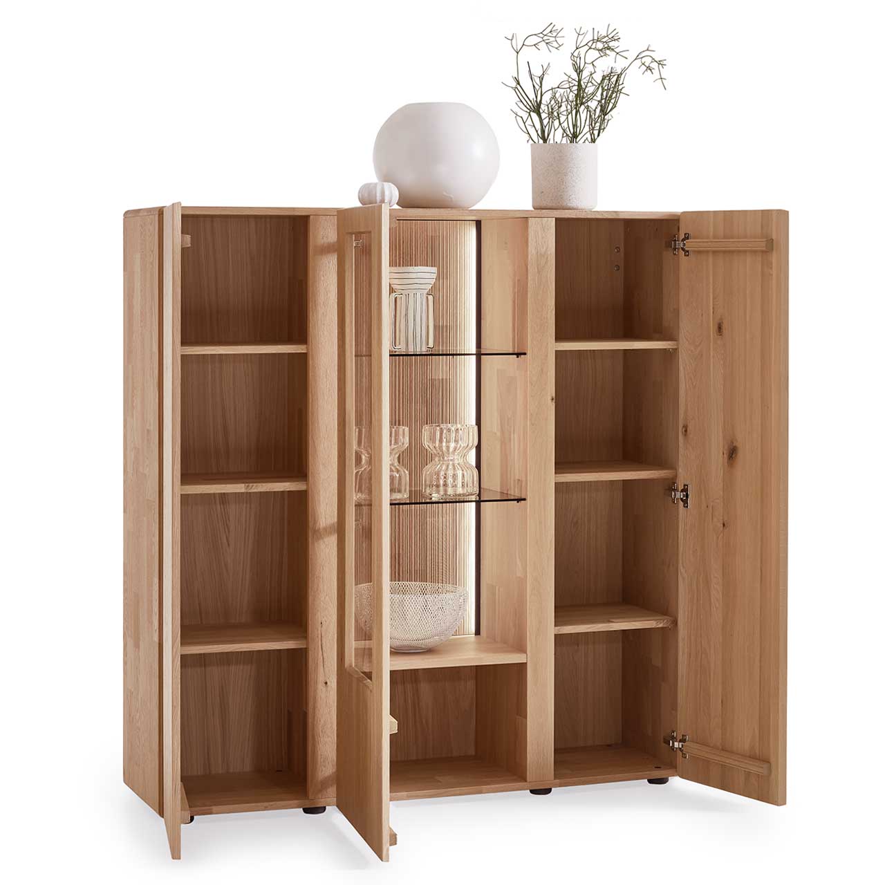Modernes 3-türiges Highboard aus massiver Kerneiche Natur mit zwei offenen Holztüren rechts und links und den dazugehörigen sechs Holzeinlegeböden, sowie mittig mit einer geöffneten Glas-/Holztür, mit zwei Glaseinlegeböden und einem Holzboden.
