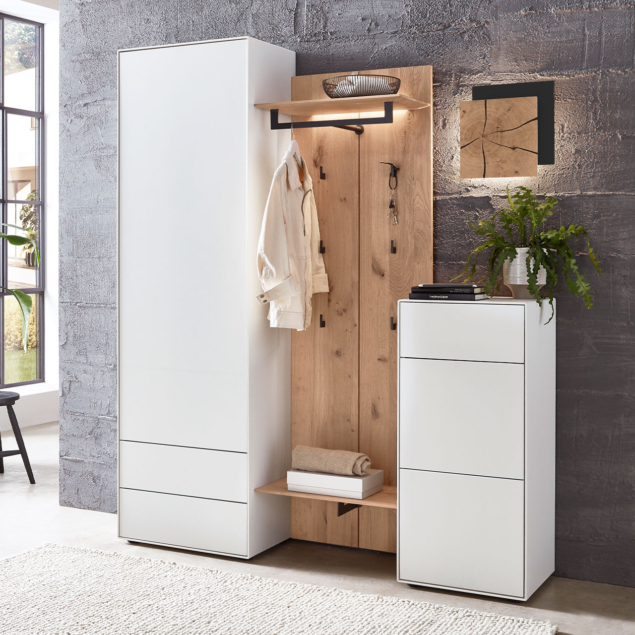 Moderne vierteilige Garderobe aus massiver Kernbirke und Kerneiche Natur: Ein Hochschrank und Stauraumschrank in Lack weiß, dazwischen eine Wandgarderobe mit Haken und Ablageböden in Holz und eine Wandleuchte mit Hirnholz.