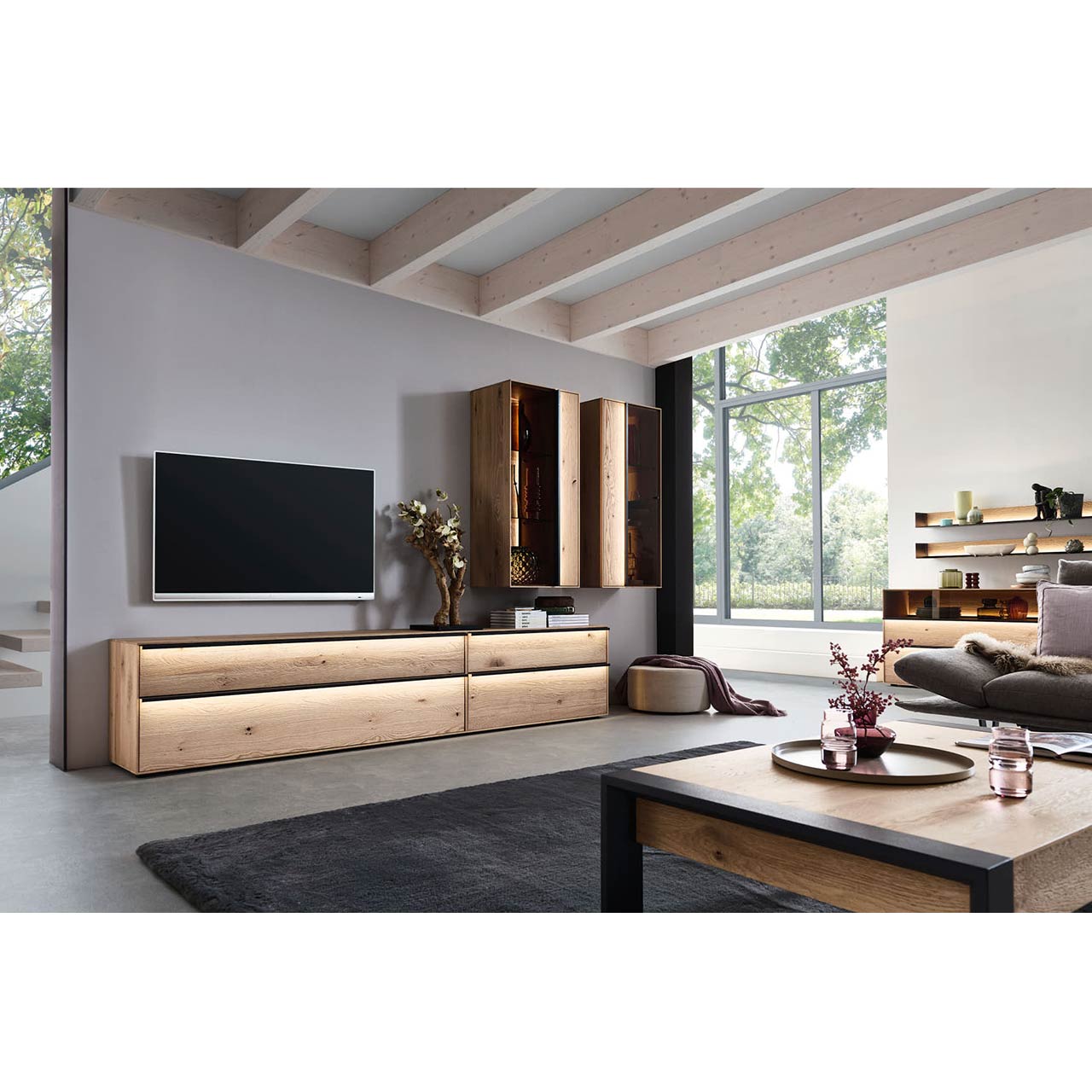 Wohnzimmer Milieubild mit Massivholz-Wohnwand bestehend aus großem Lowboard mit 2 Hängevitrinen