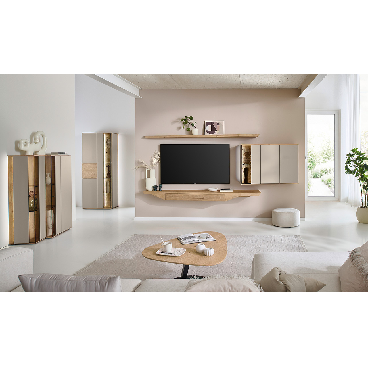 Wohnzimmer mit moderner Massivholzwohnwand mit Lack Sand bestehend aus Hängelowboard, Hängevitrine und Wandboard - im asymmetrischen Design. Links passendes Highboard mit Glastüren, davor asymmetrischer Beistelltische aus Holz.