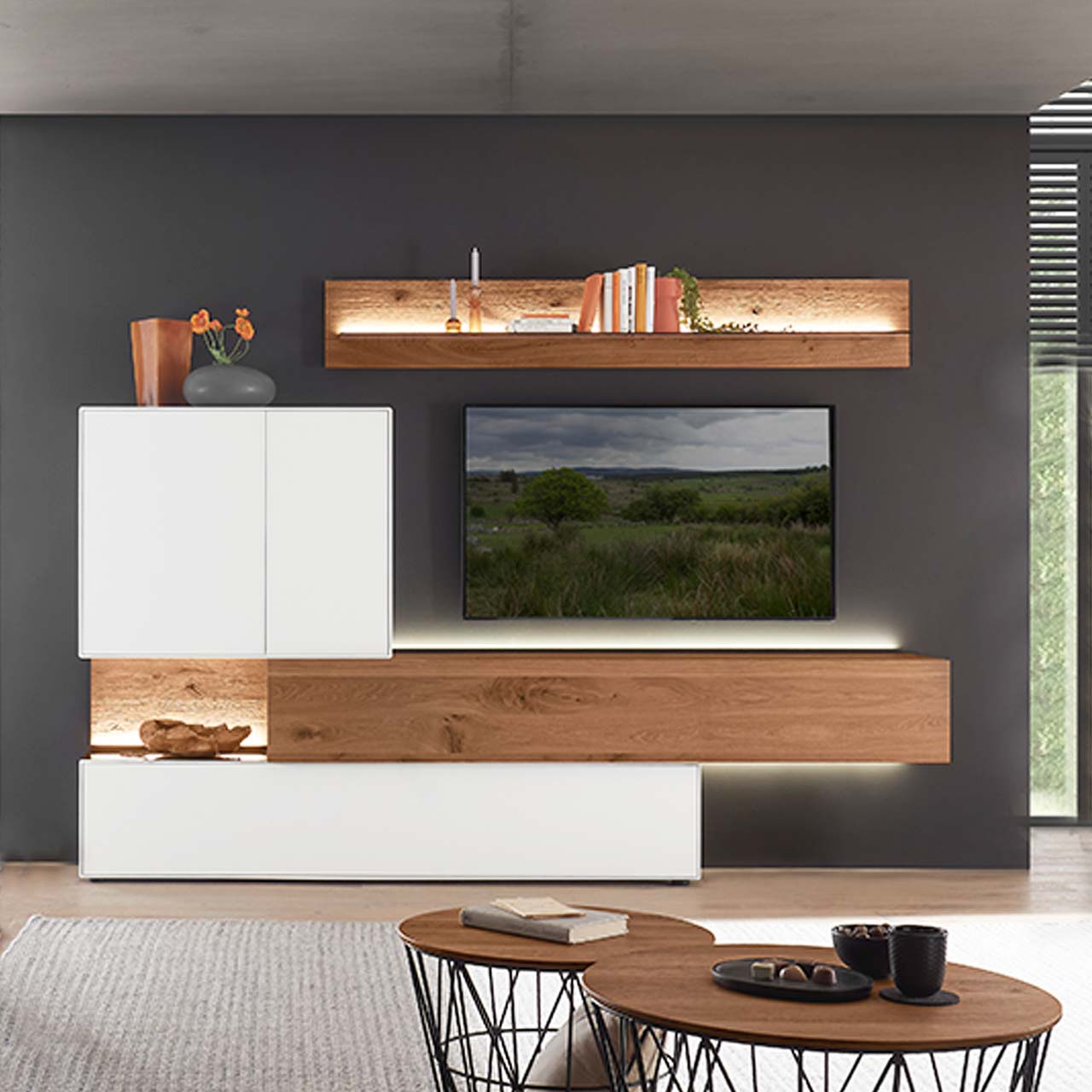 Hartmann TORIDO - Wohnwand 7270 Nr. V28 - fünfteilig - Birke Lack weiß & Kerneiche Umato Moderne Wohnwand aus massiver Birke weiß lackiert mit Kerneiche Umato bestehend aus einem Holz-Hängelowboard seitlich eingefasst in einen weißen Unter,- und Hängeschrank mit beleuchteter Rückwand und einem Holz-Wandpaneel mit Glasablageboden.
