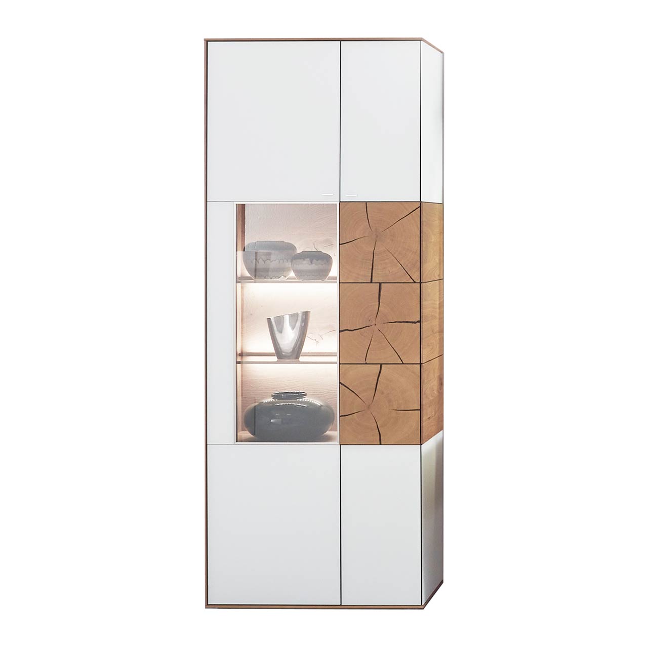 Hartmann CAYA - Standvitrine 7170-0085W li. Moderne Standvitrine aus massiver Kerneiche mit Mattglas weiß Front. Links mit Glastür, rechts mit Holztür mit Mattglas weiß Front und drei dekorativen Hirnholzscheiben.