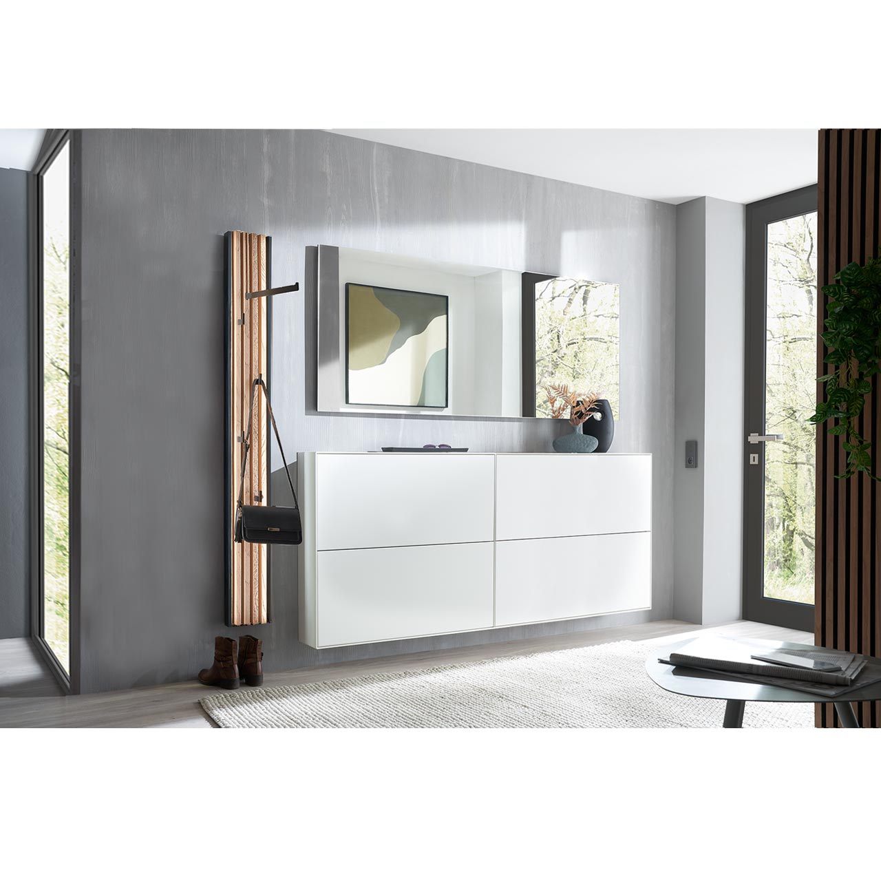 Flur mit modernen Garderobenmöbeln aus massiver Kernbirke weiß lackiert: Zwei Schuhkipper in Lack weiß, darüber ein langer, rechteckiger Wandspiegel, links ein Garderobenpaneel mit Kleiderstange und Haken und Lamellen-Akzent.