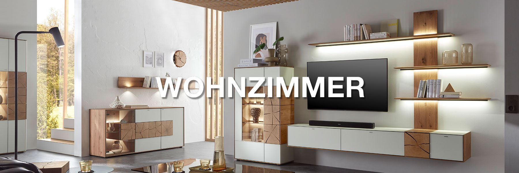 Hartmann Möbel - Kategorie WOHNZIMMER - Sideboards, Lowboards Wohnwände uvm. Wohnzimmermöbel der Marke Hartmann. Moderne Möbel wie Wohnwände, Highboards, Sideboards, Couchtische uvm. gefertigt aus massivem Holz und kombiniert mit Glas, Lack oder Metall. Ambientebild zeigt eine Massivholz Wohnwand der Serie CAYA in modernem Weiß.