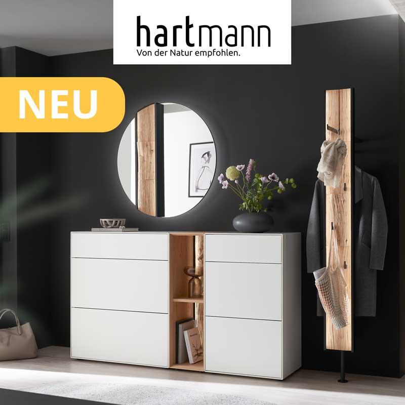 Hartmann SALVO - Flurmöbel aus massiver Kerneiche Natur und Birke weiß lackiert kombiniert mit Akzenten aus echter Baumrinde, Holzlamellen oder Spaltholz. Ambientebild zeigt zwei weiße Stauraumschränke, runden Wandspiegel und eine Wandgarderobe.